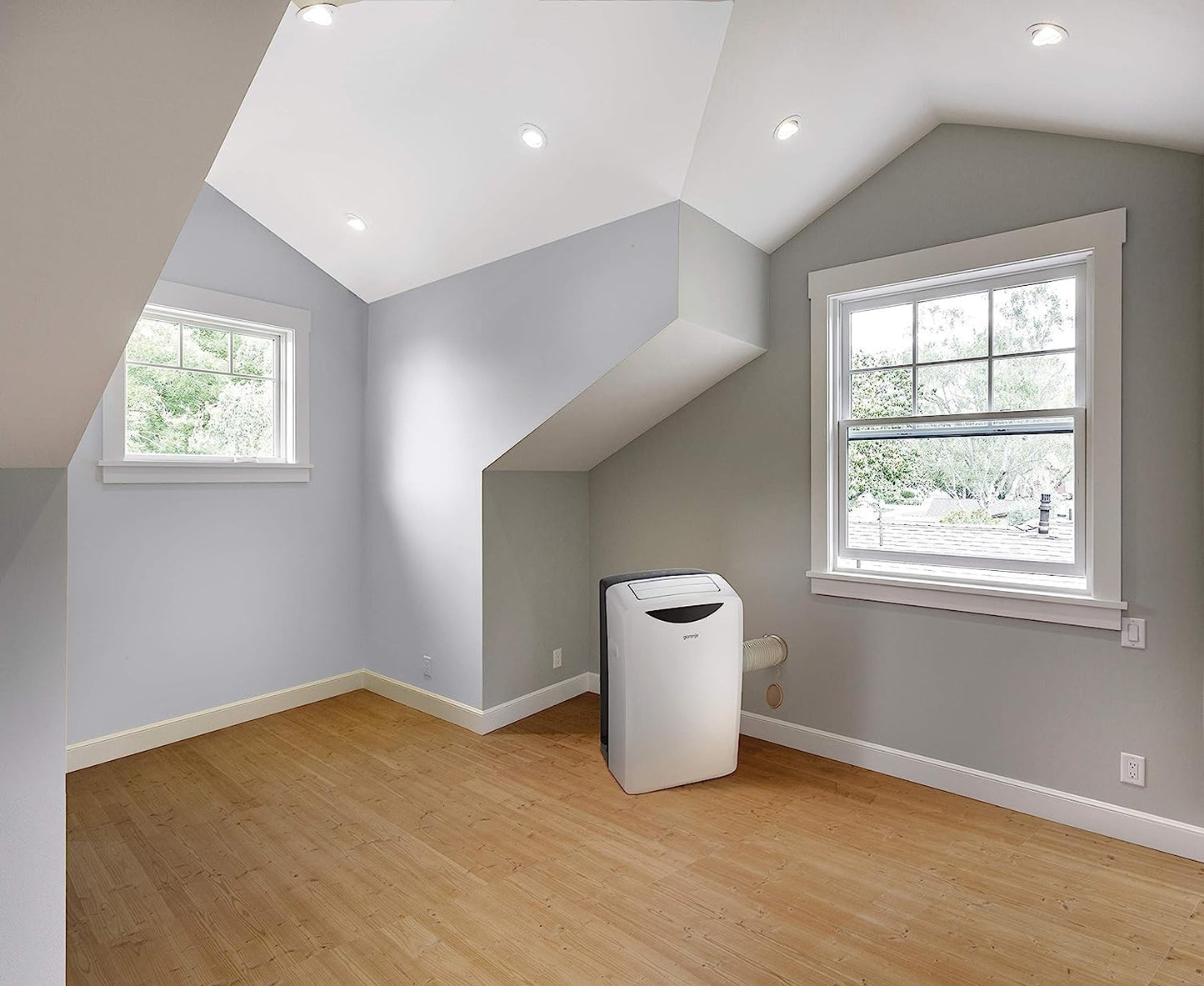 Portatile GORENJE climatizzatore in una stanza con pareti grigie e finestre luminose, ideale per ambienti fino a 25 m2.