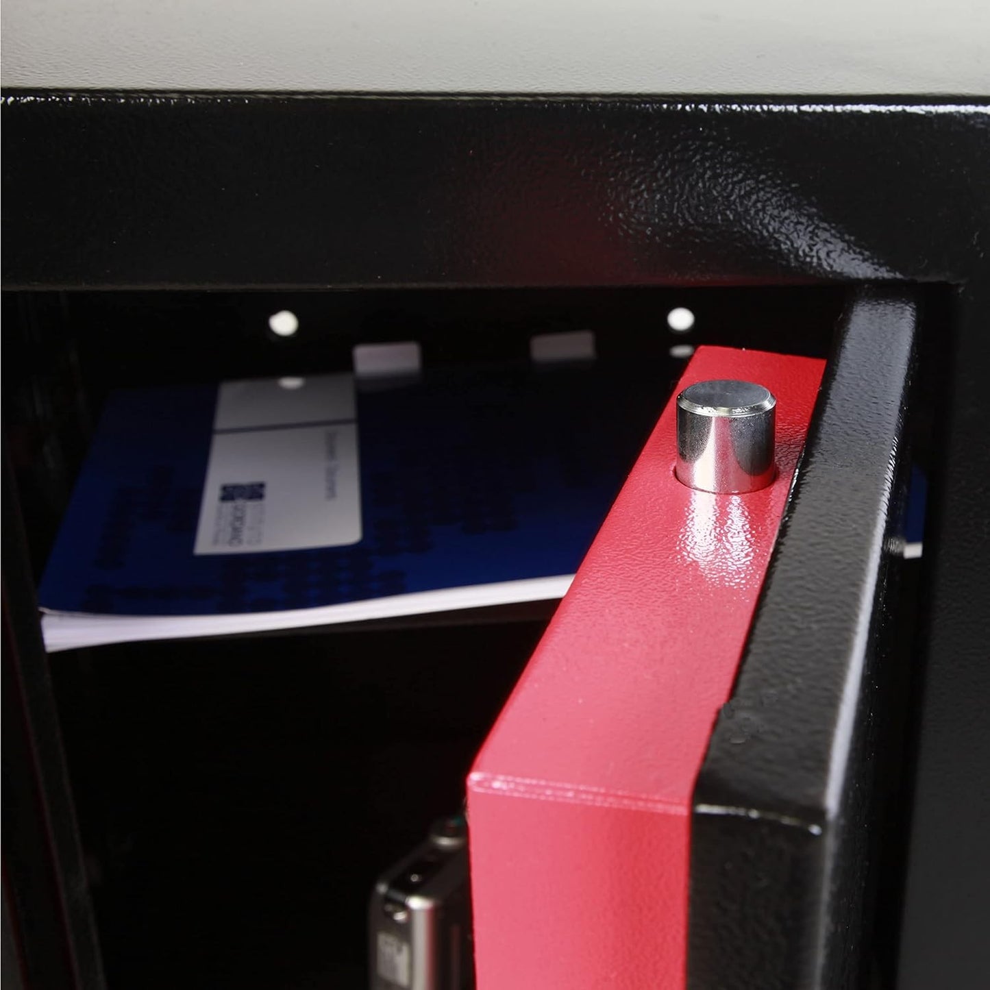 Interno di un armadio di sicurezza Technomax con ripiani, documenti e un blocco di sicurezza.